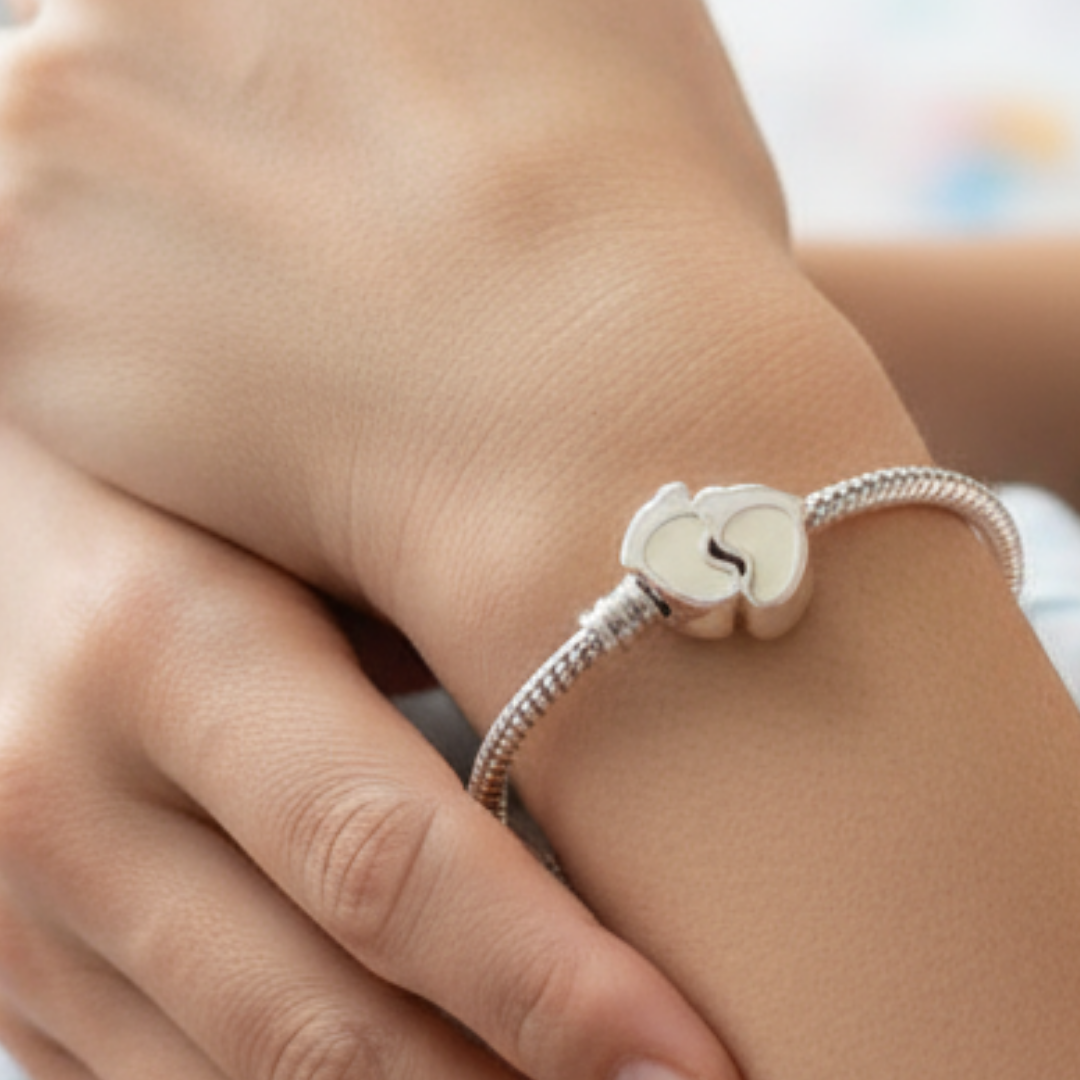charm con forma de piececitos de leche materna puesto en la muñeca, joya maternal personalizada