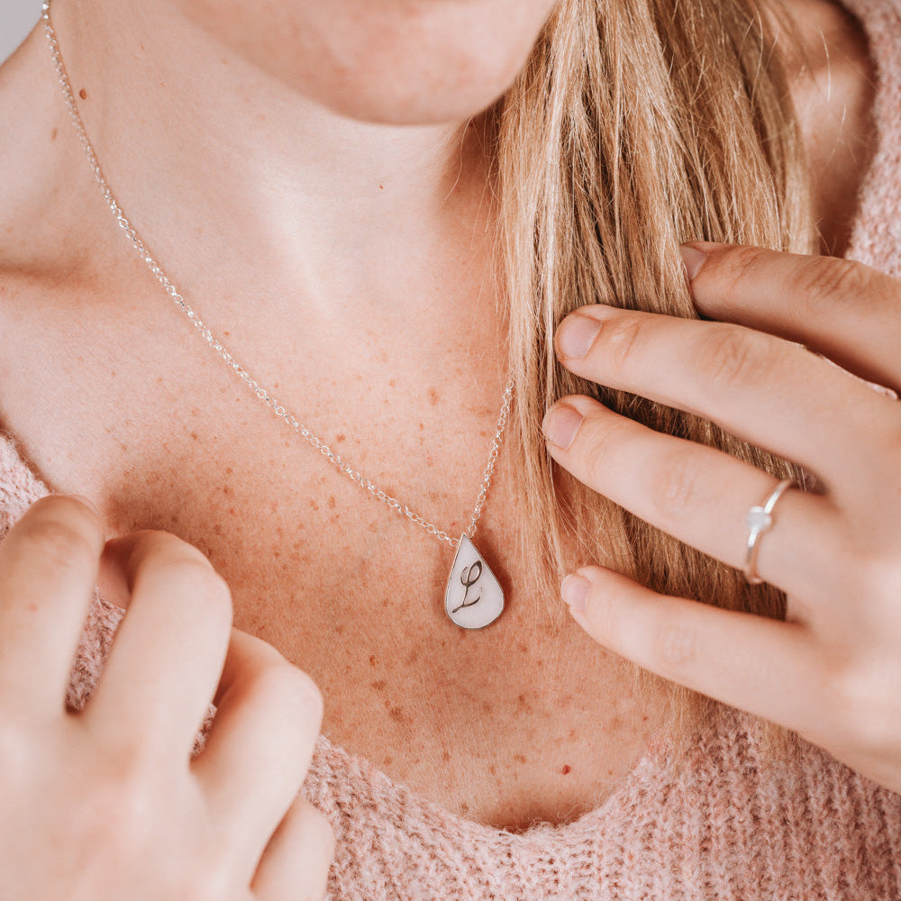 Colgante con forma de gota de leche materna con inicial puesto en el cuello, joya maternal personalizada
