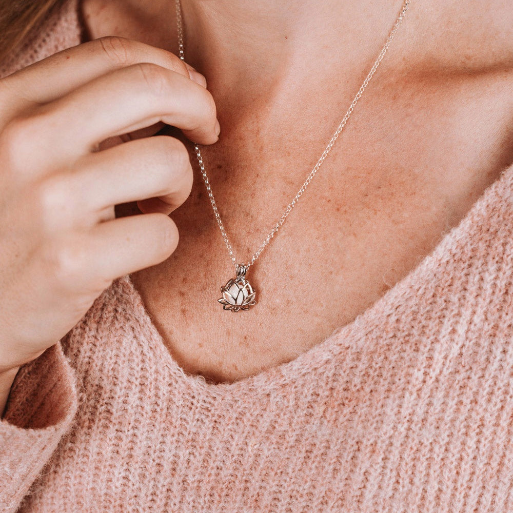 Colgante guarda tesoros flor de loto que guarda dentro una perla de leche materna puesto en el cuello