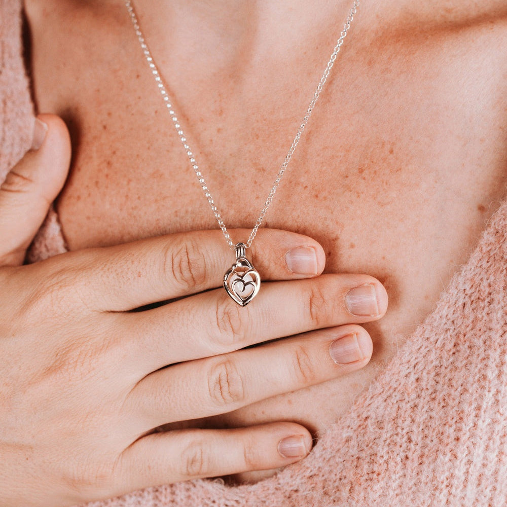Colgante guarda tesoros mama y bebé que guarda dentro una perla de leche materna en plata de ley puesto en el cuello, joya maternal personalizada