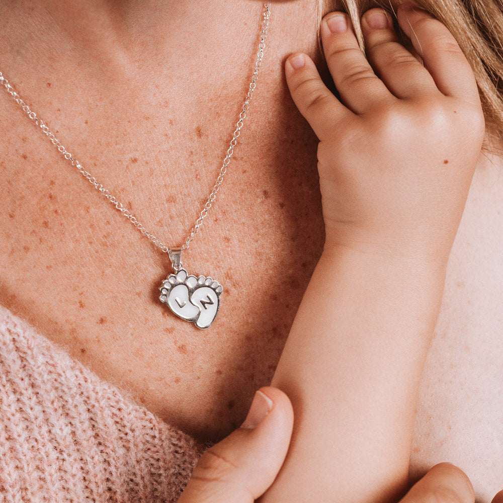 Colgante con forma de piececitos de bebé con iniciales personalizadas de leche materna puesto en el cuello, joya maternal personalizada