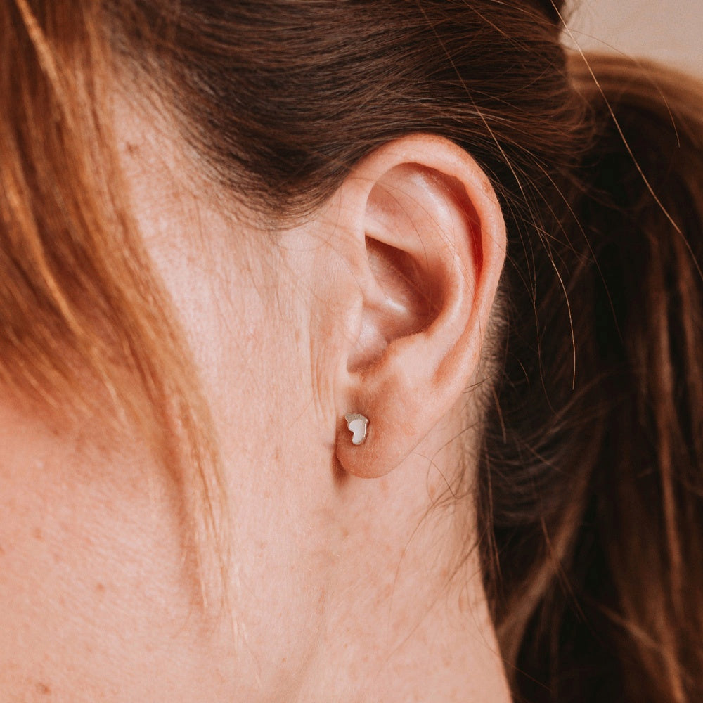 Pendientes de piececitos con leche materna puestos en la oreja, joya maternal personalizada en plata de ley