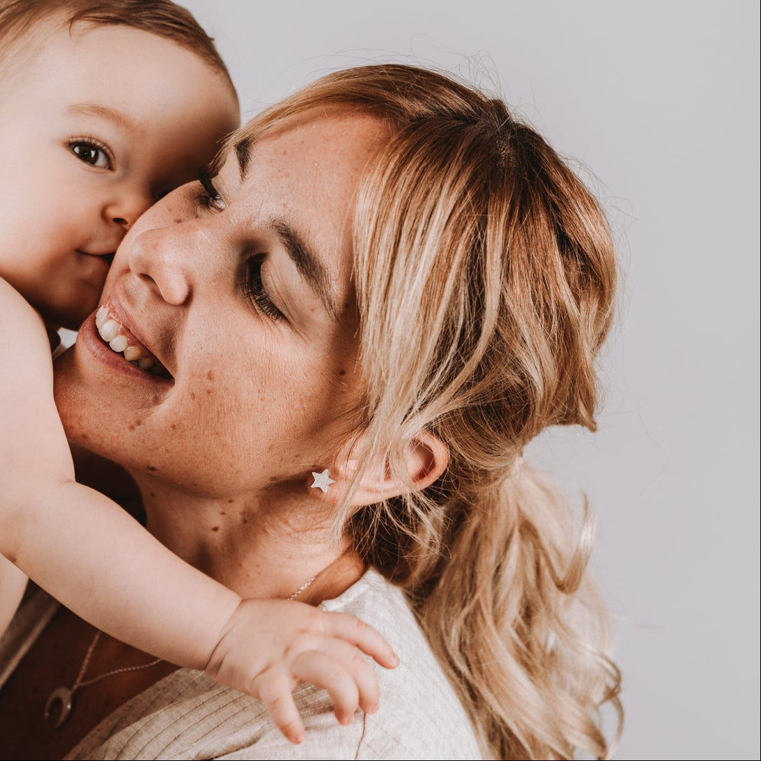 Pendientes de estrella con leche materna puestos en la oreja, joya maternal personalizada en plata de ley