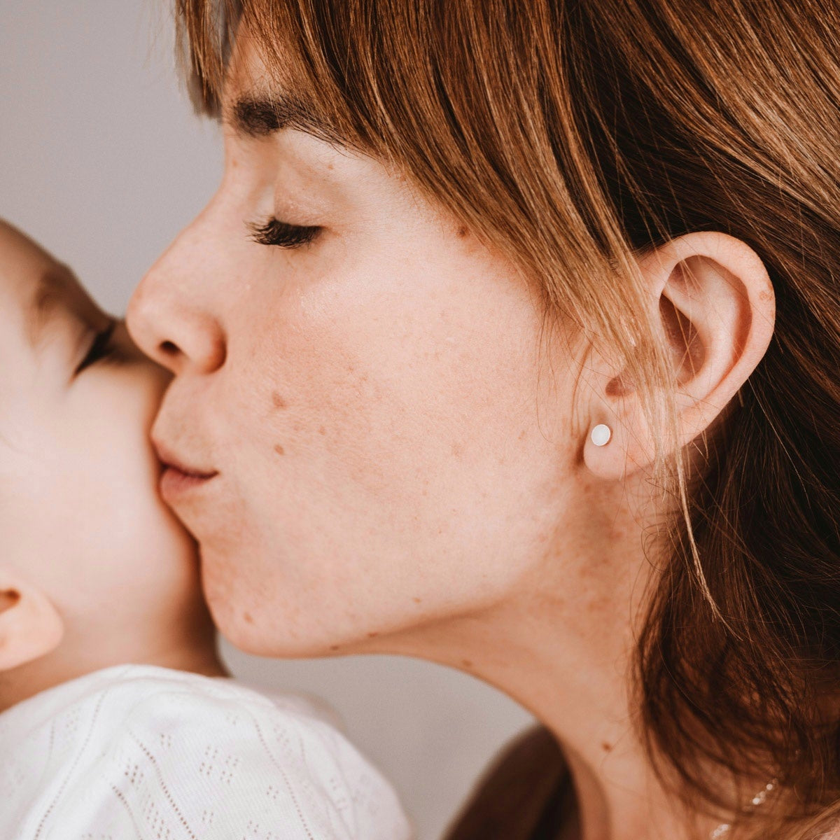 Pendientes con mini círculo de leche materna puestos en la oreja, joya maternal personalizada en plata de ley