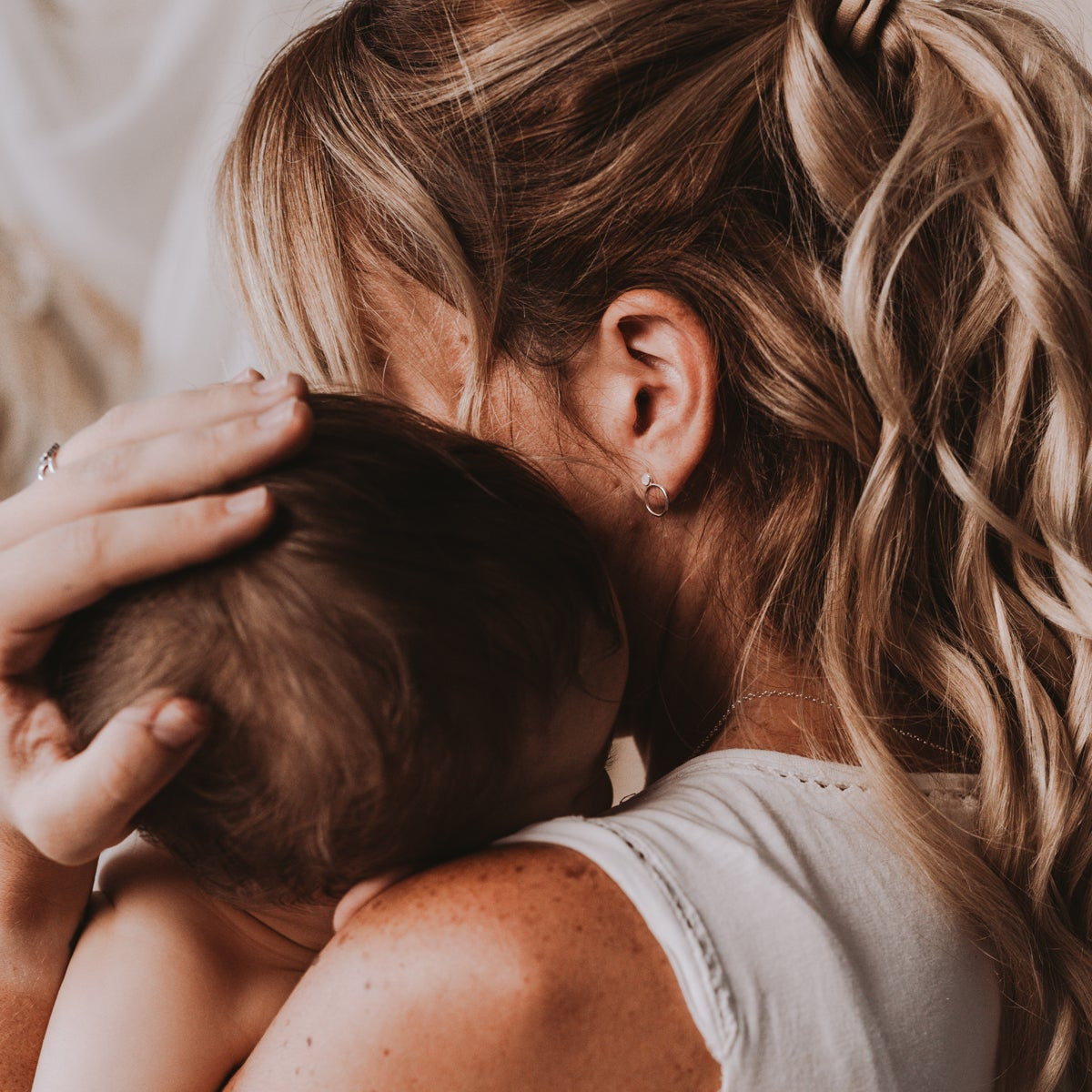 Pendientes con perla de leche materna puestos en la oreja, joya maternal personalizada en plata de ley