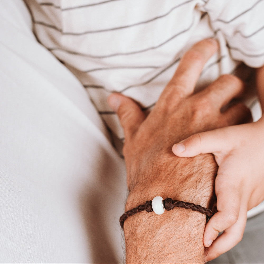 Pulsera de cuero con cuenta redonda de leche materna puesto en la muñeca, joya maternal personalizada

