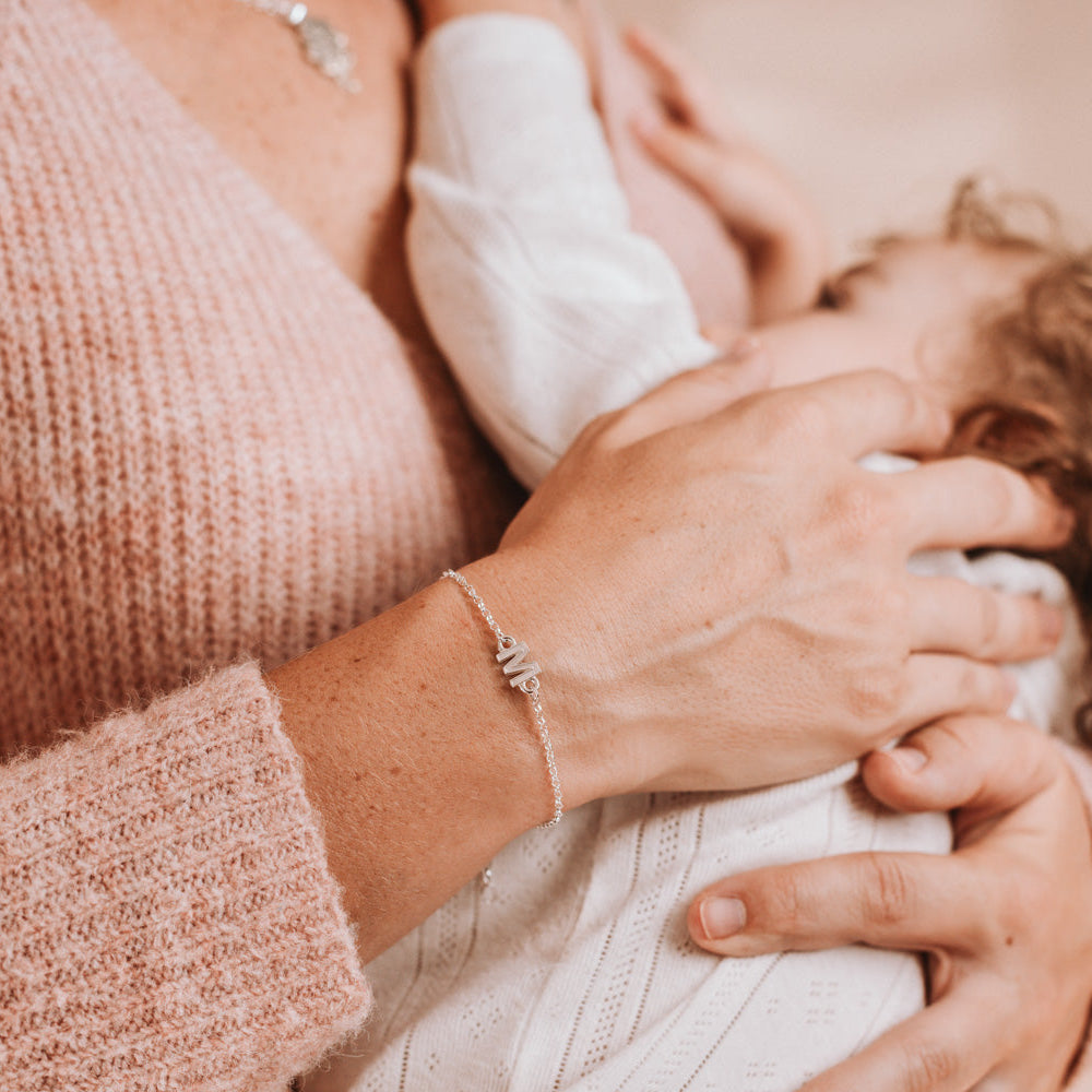 Pulsera con inicial de leche materna puesto en la muñeca, joya maternal personalizada
