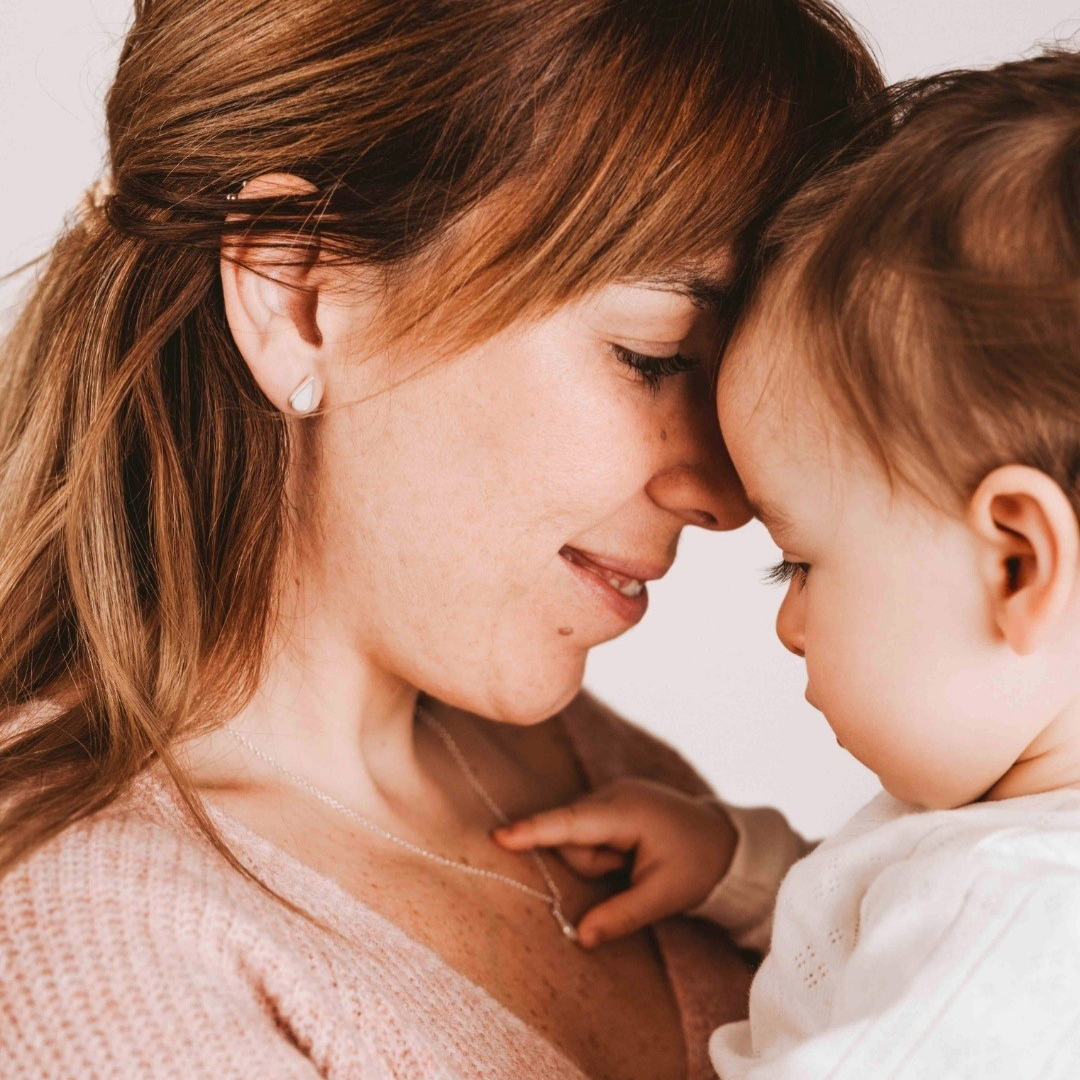 Pendientes de gota con leche materna puestos en la oreja, joya maternal personalizada en plata de ley